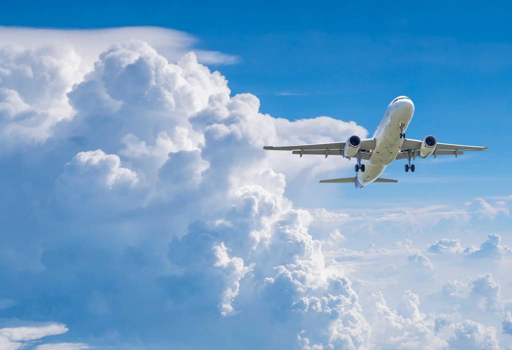 plane flying under blue sky and white cloud