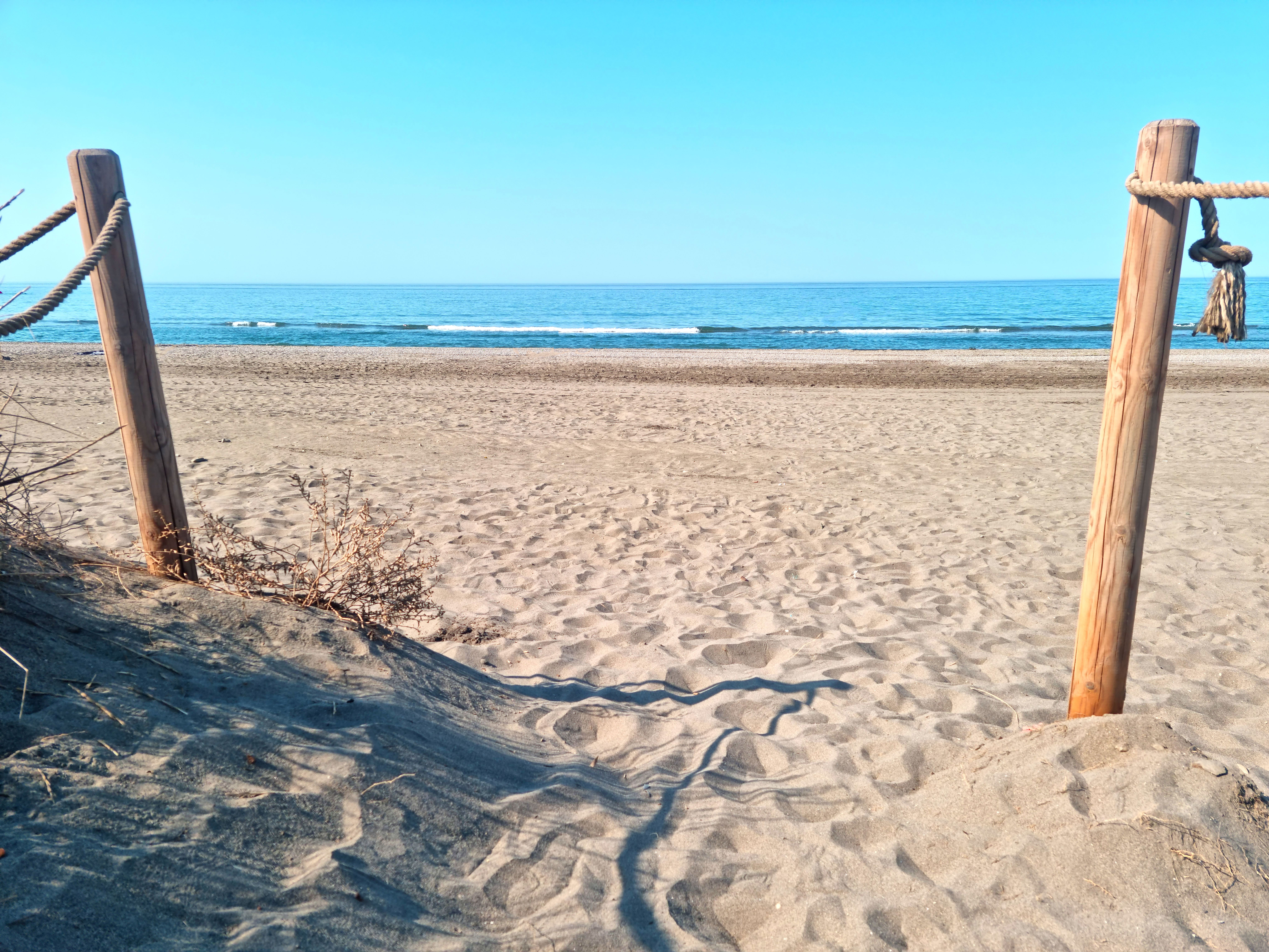Entrance to an empty sandy beach in Spain