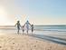 Rearview shot of a happy family walking towards the sea on a beach