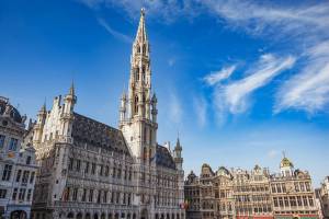 View of the intricate Brussels Town Hall building with tall spire and other guild houses in the Grand Place in Brussels, Belgium