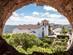 View of the whitewashed Santa Maria Church framed by a stone wall on a bright day