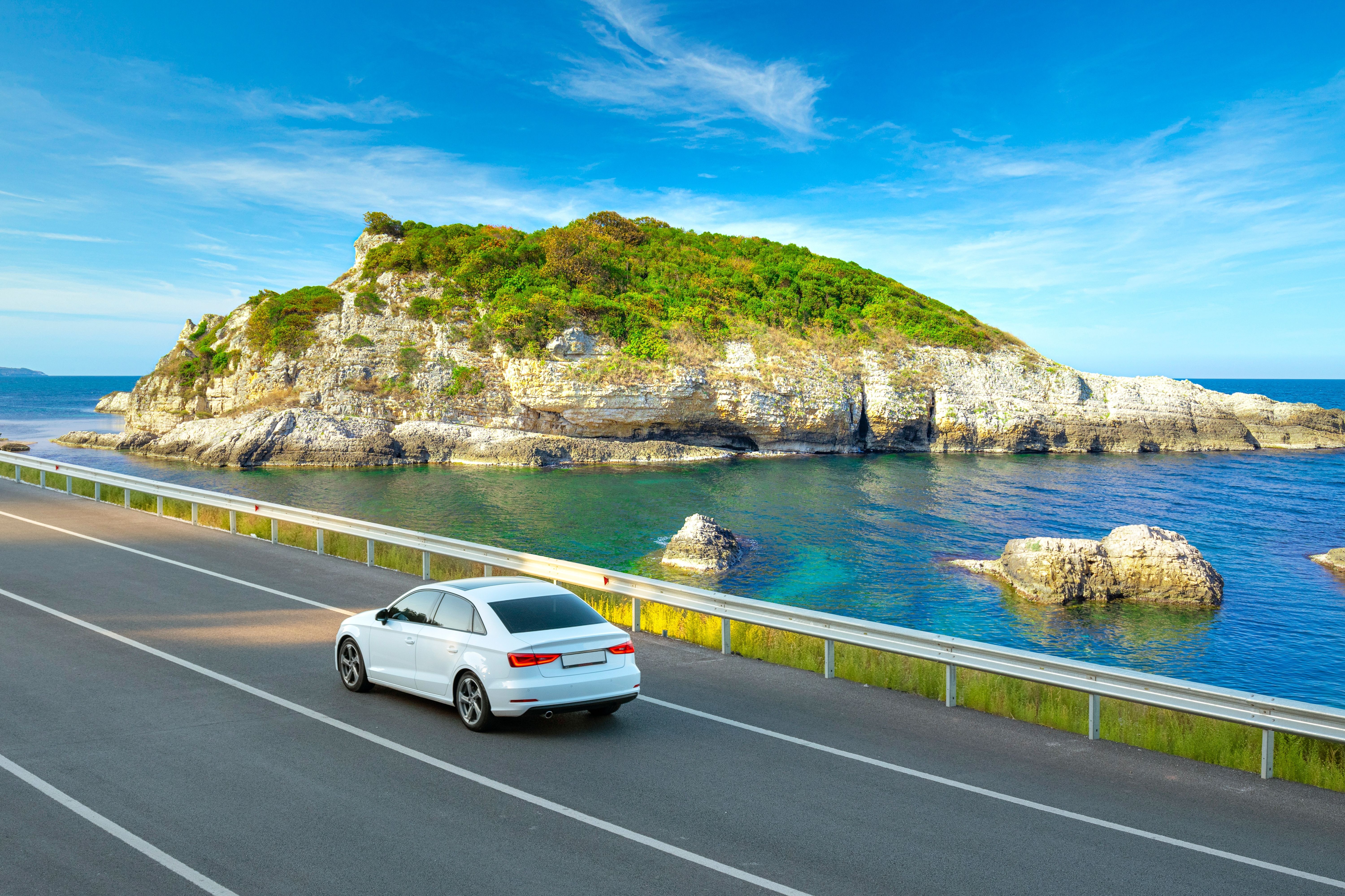 White car driving along a coastal road in Spain