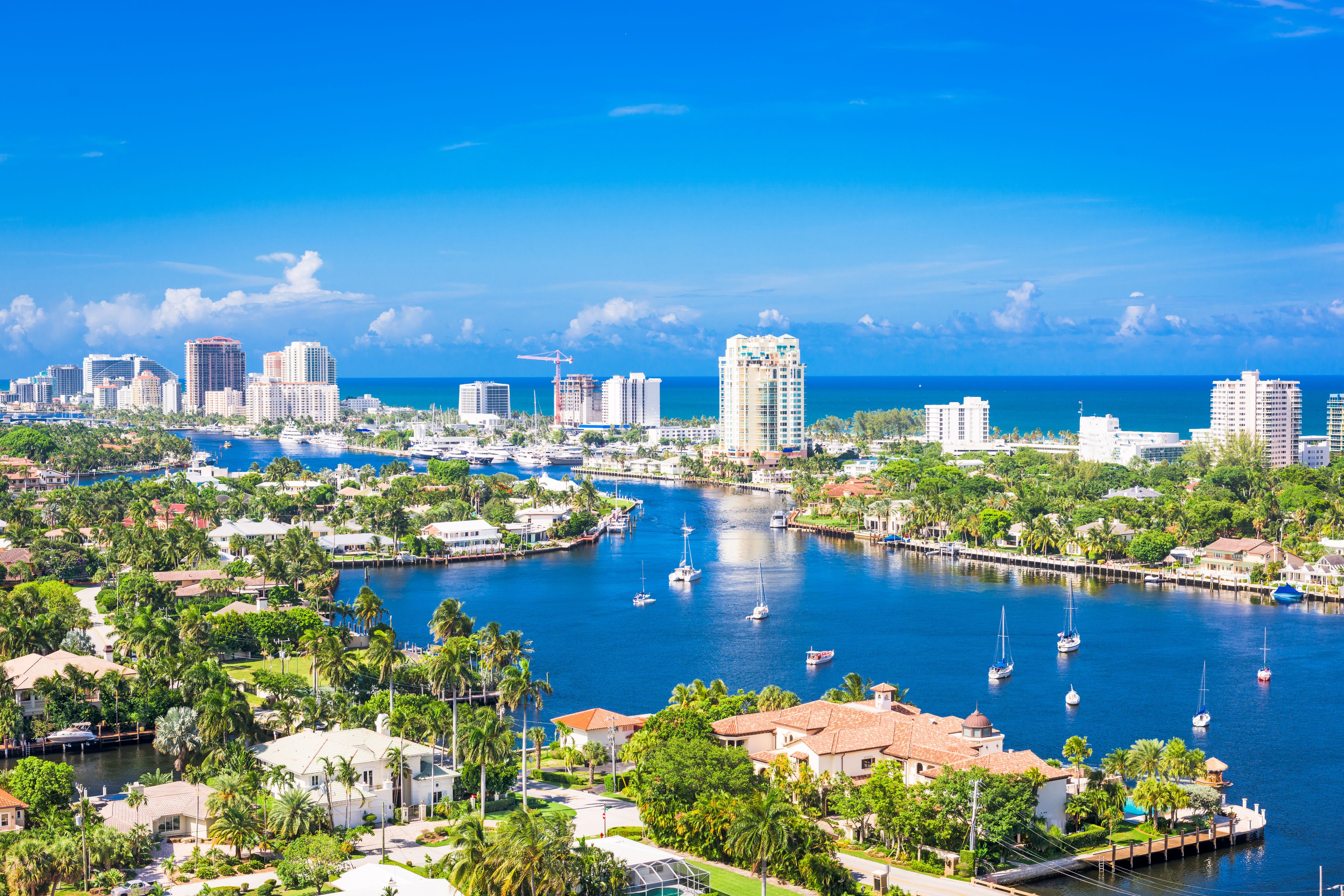 A view of Fort Lauderdale in Florida, showing the skyline over Barrier Island and boats anchored in the blue water
