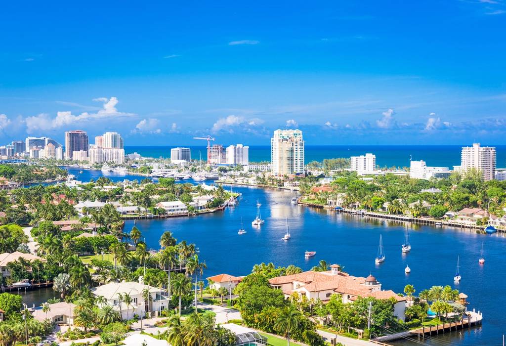 A view of Fort Lauderdale in Florida, showing the skyline over Barrier Island and boats anchored in the blue water