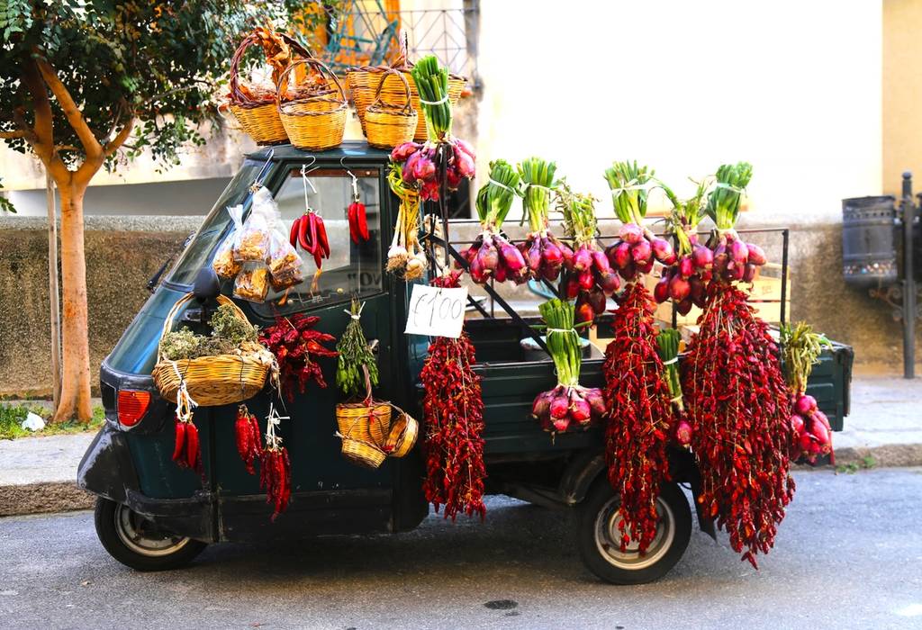 A picture of a small truck covered in vegetables and chillies showing the local produce of Calabria in Italy