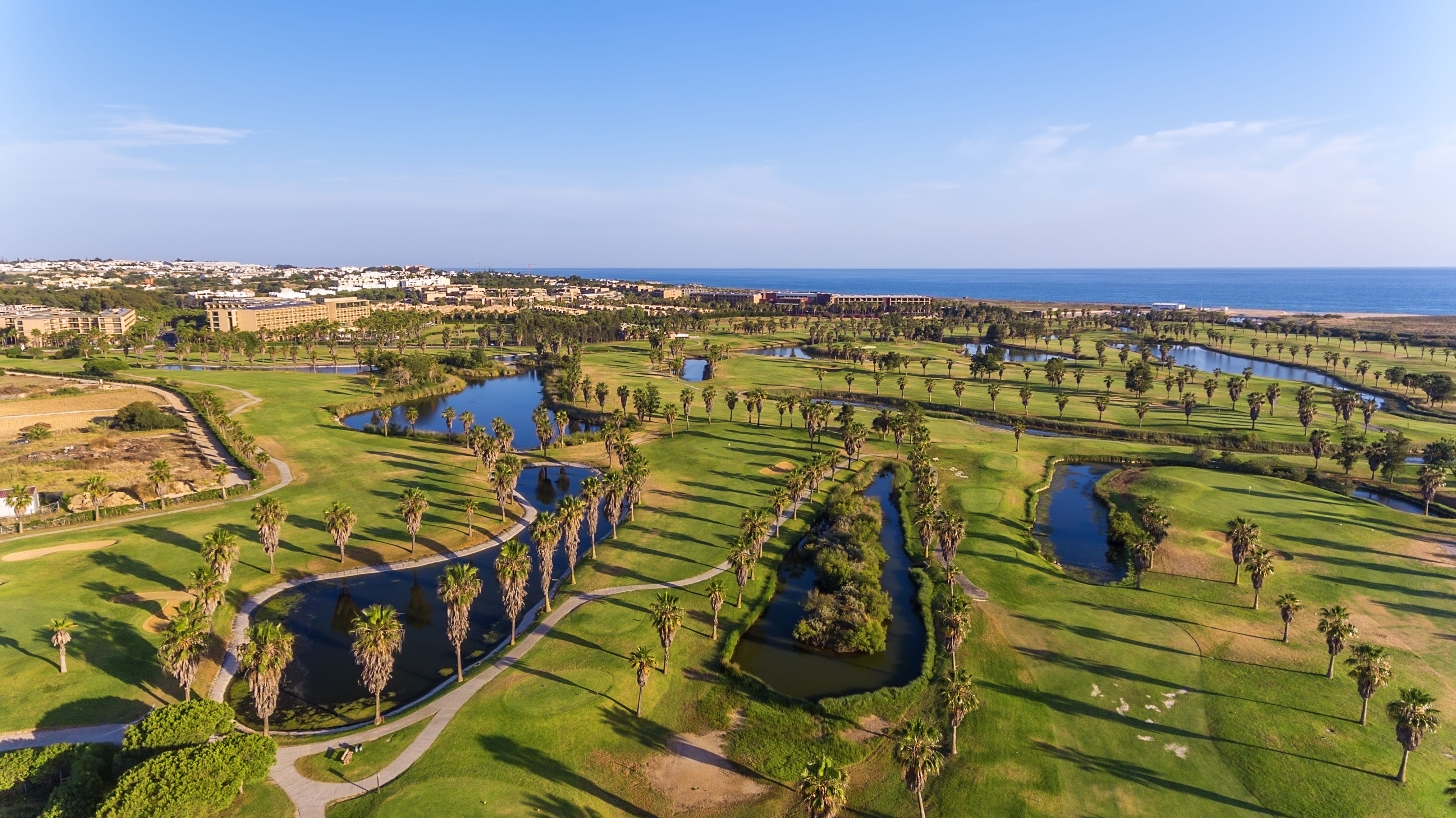 A luxury golf course by the sea with palm trees and lakes in the Algarve, Portugal