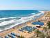 View across blue parasols and yellow sun-loungers on the huge sandy beach of Maspalomas