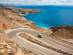 A car driving on a winding coastal road in Crete, Greece