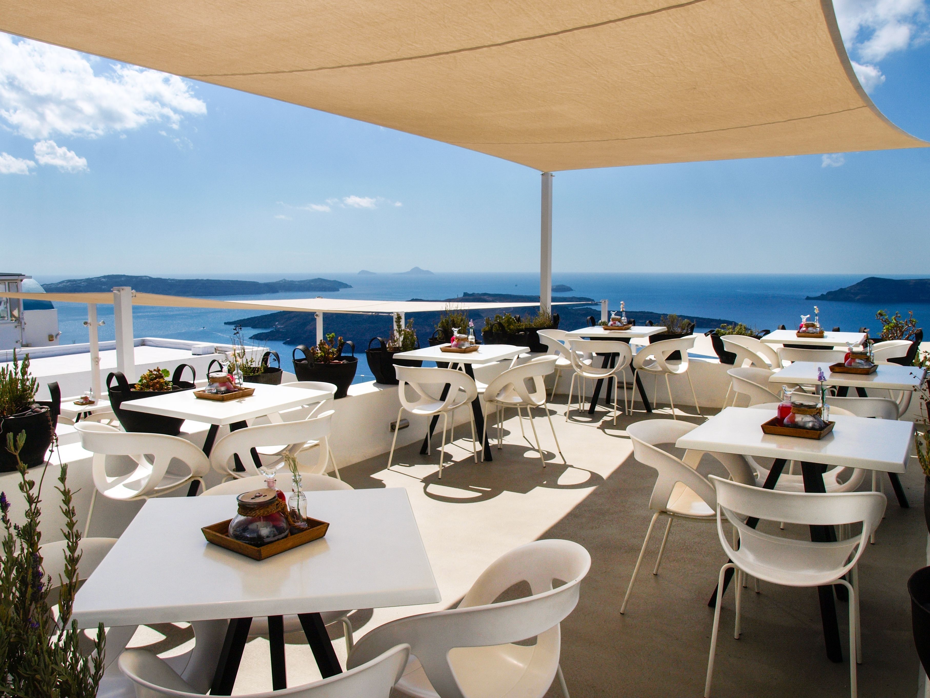 An open-air cafe overlooking the caldera in Santorini, Greece