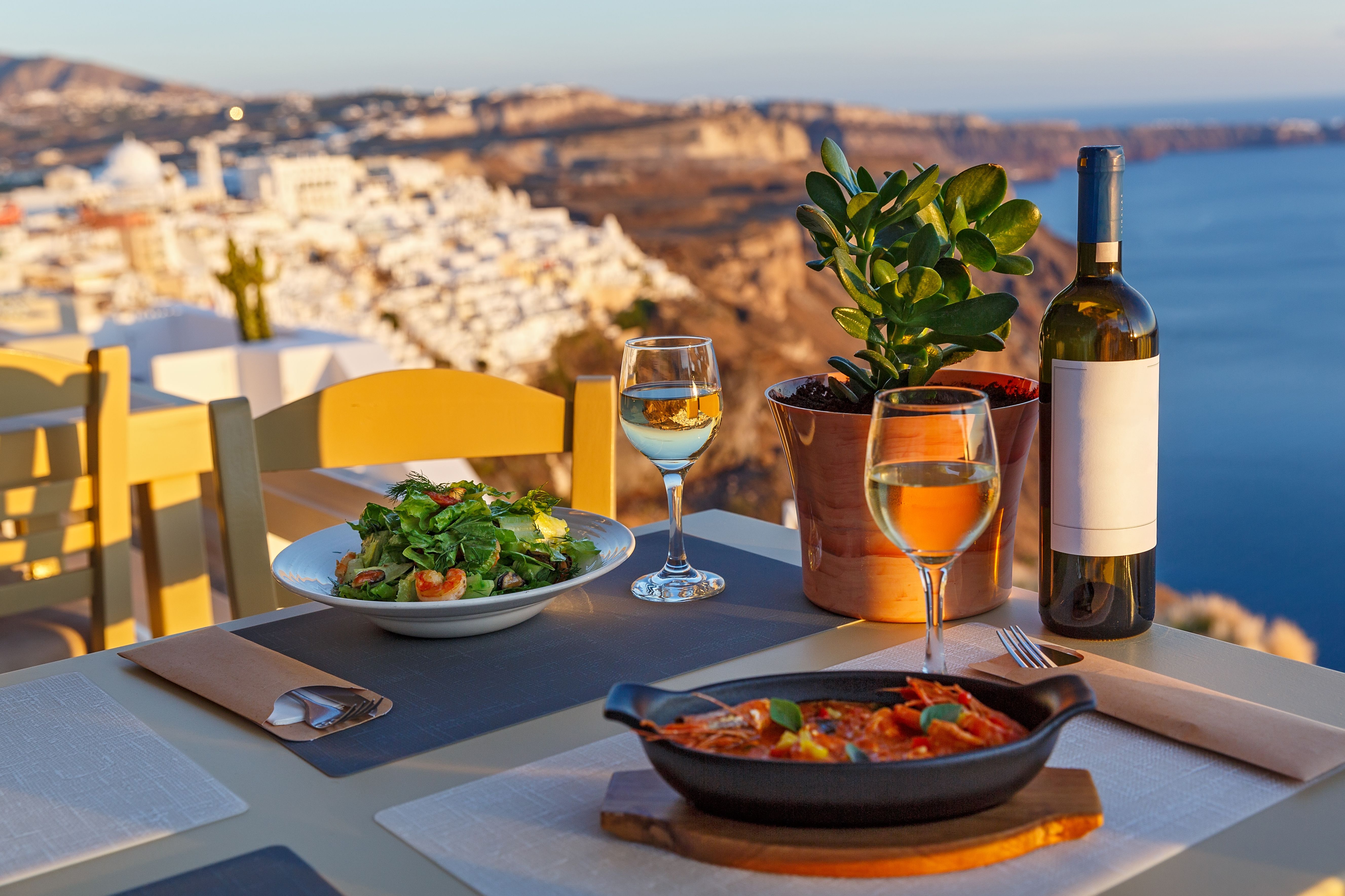 Dinner for two in a restaurant overlooking the sea and the island of Santorini, Greece