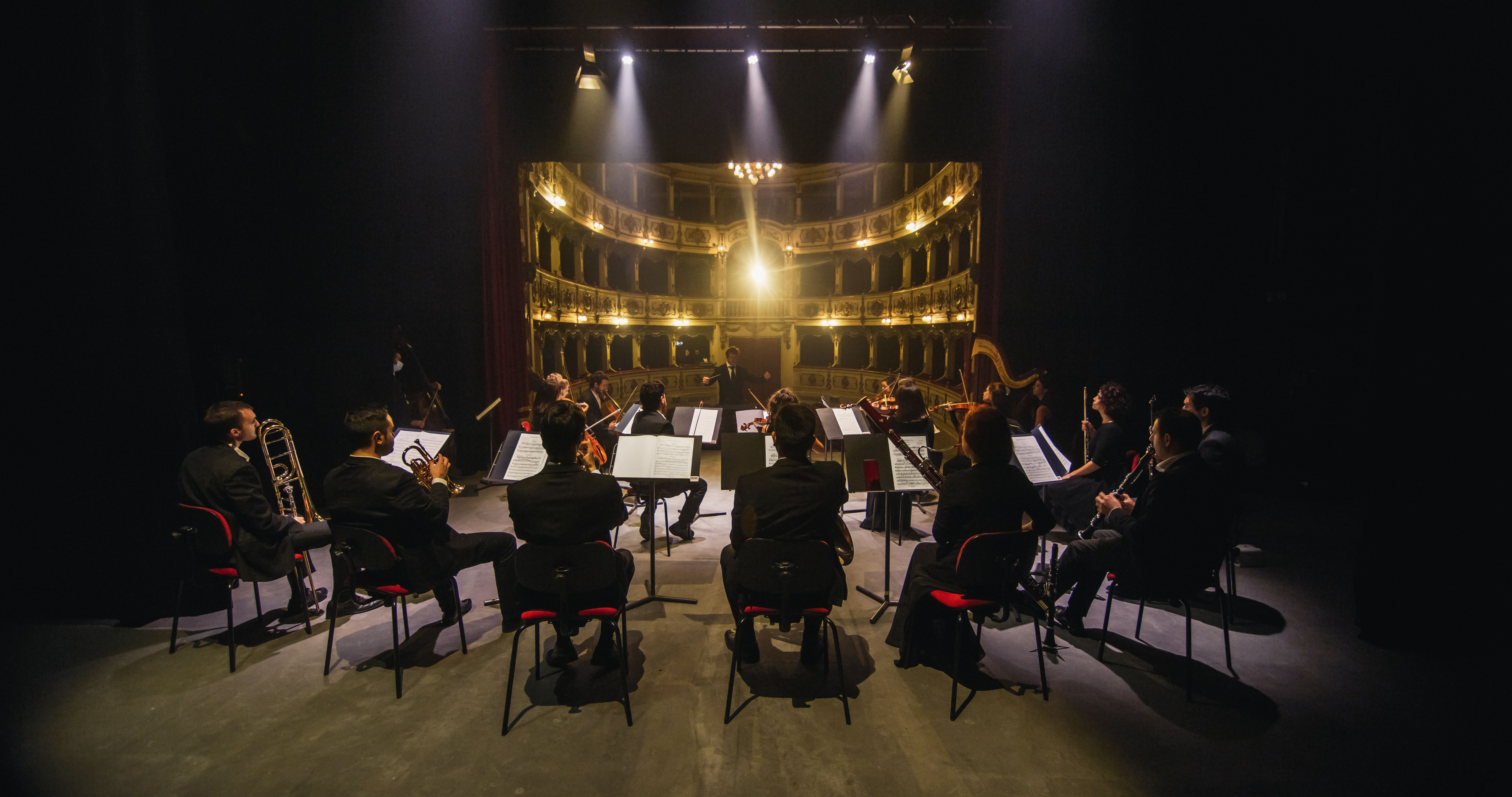 View of a conductor leading an orchestra on an opera theatre stage
