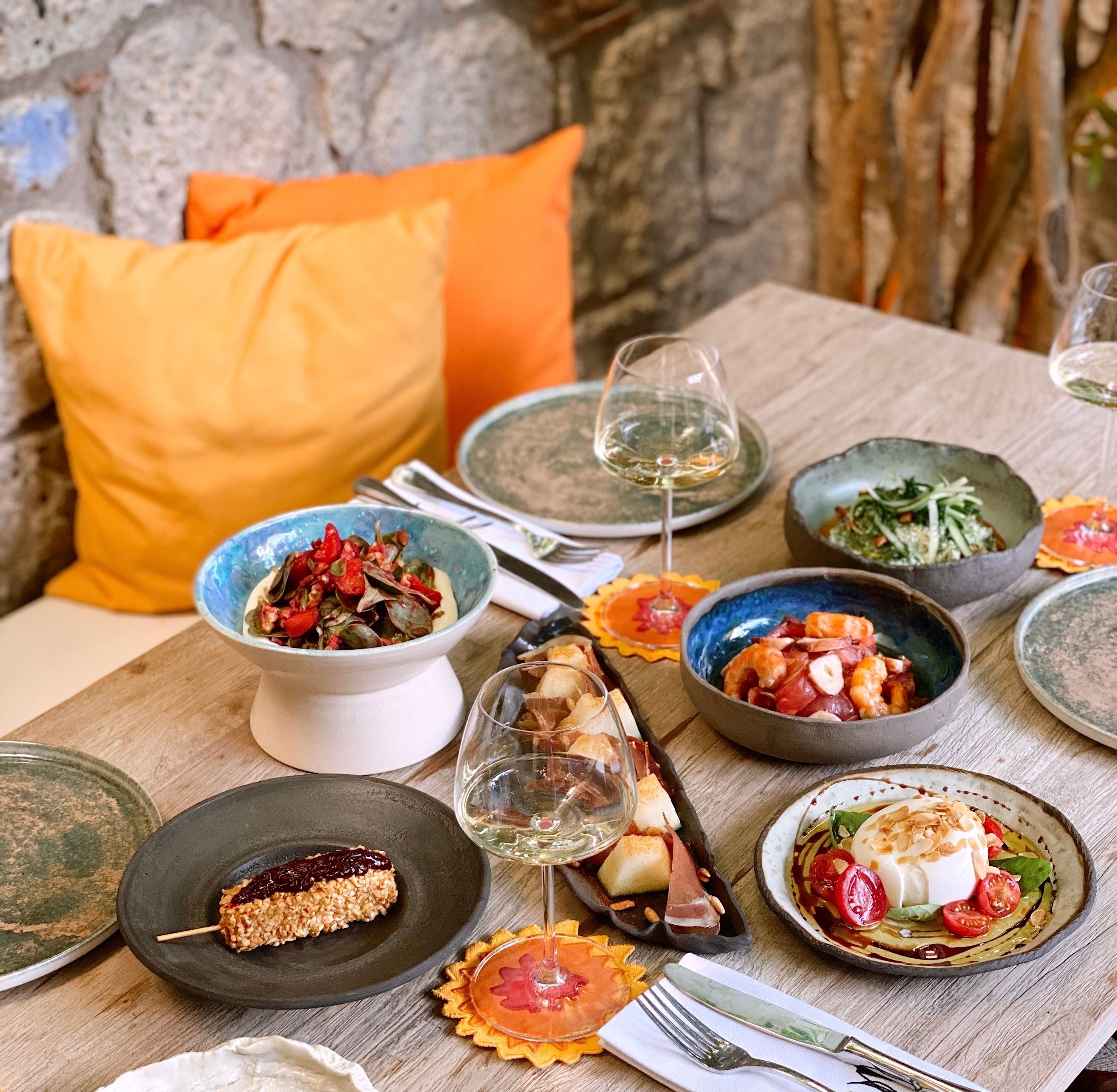A restaurant table in Alacati, Turkey with various traditional dishes and wine