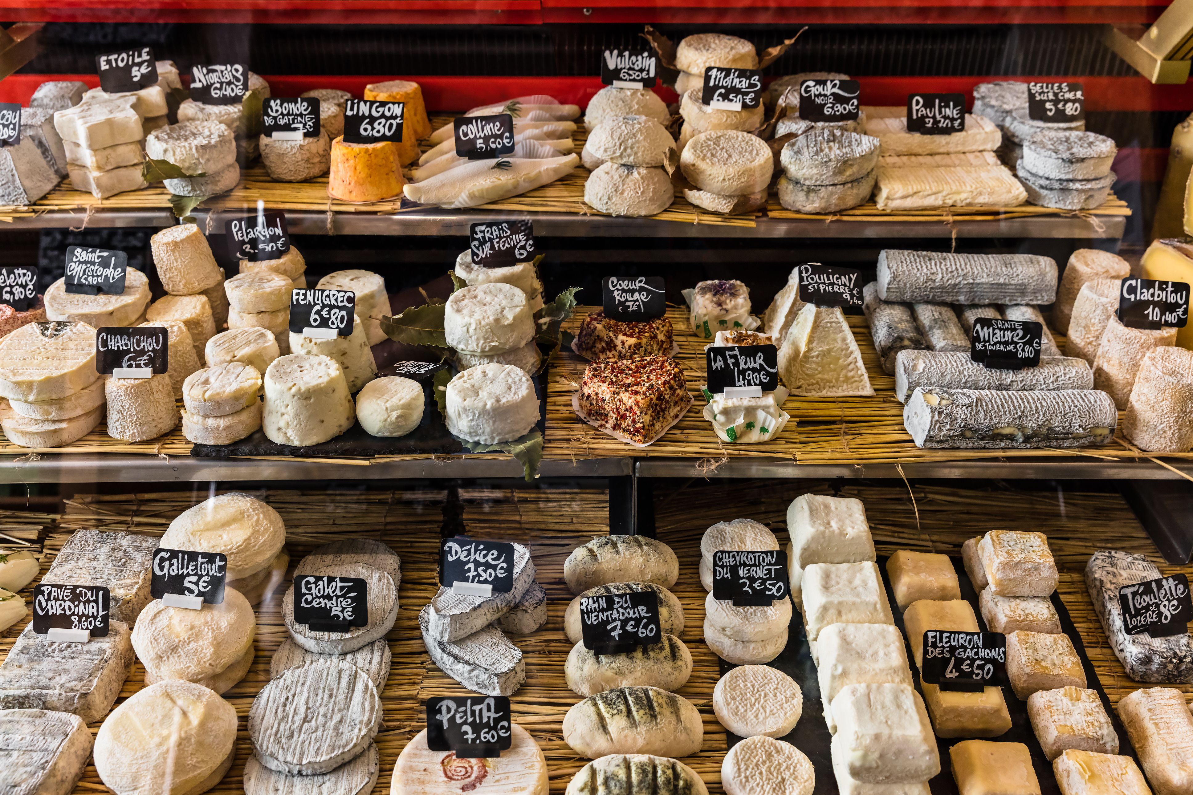 A close up of a market stall in Paris selling an assortment of cheese