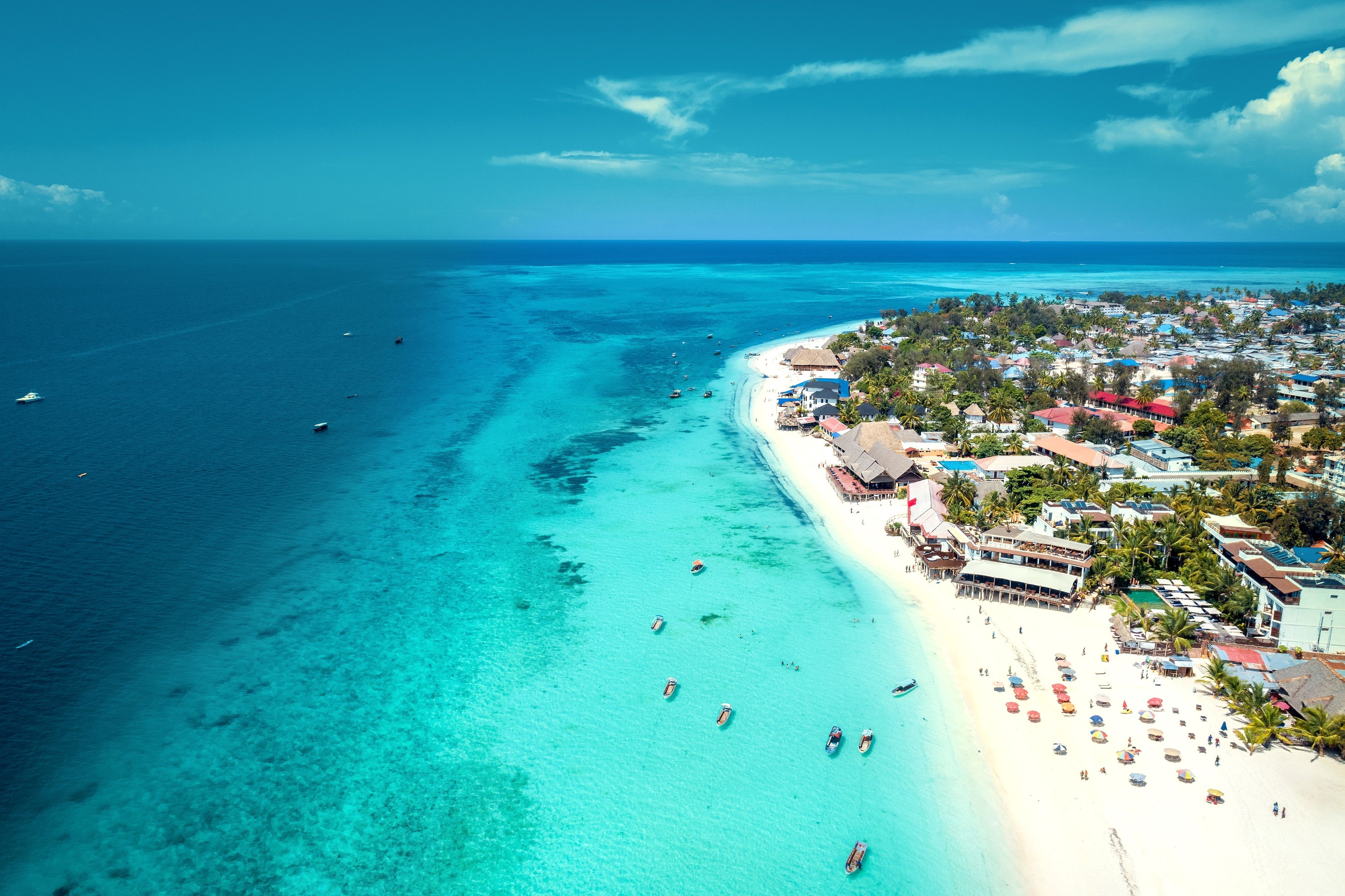 Aerial view of the white-sand Nungwi Beach in Zanzibar with luxury resorts along its shores and turquoise ocean water