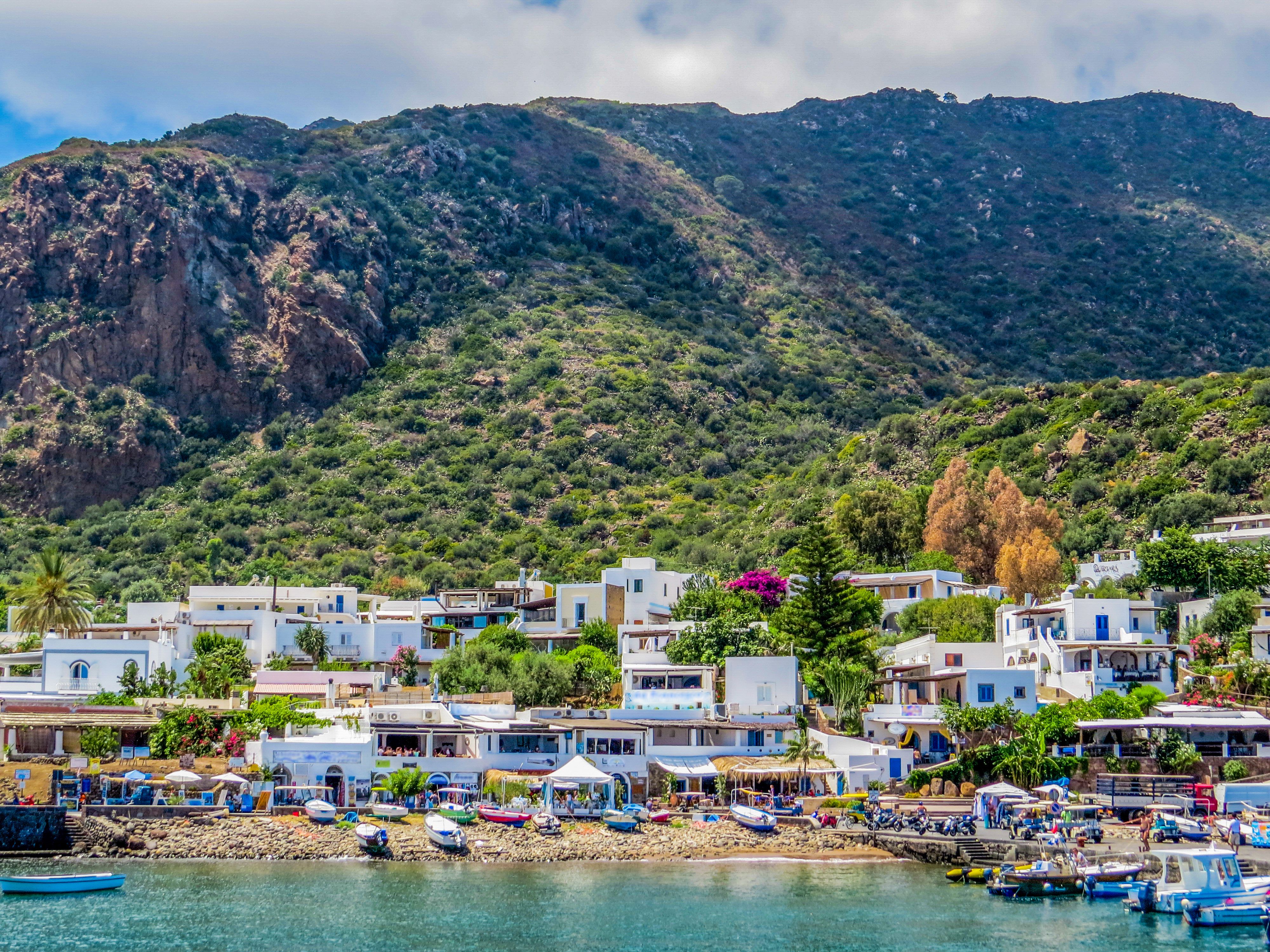 View of white-washed houses and colourful boats on the island of Panarea in Sicily