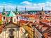 An aerial city view of Prague's terracotta rooftops and colourful buildings on a summer's day