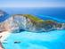 An aerial view on the famous Shipwreck Beach in Zante with boats on sparkling blue water and surrounded by white cliffs covered in green trees