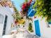 Traditional white-washed street with bougainvillea in Paros, Greece