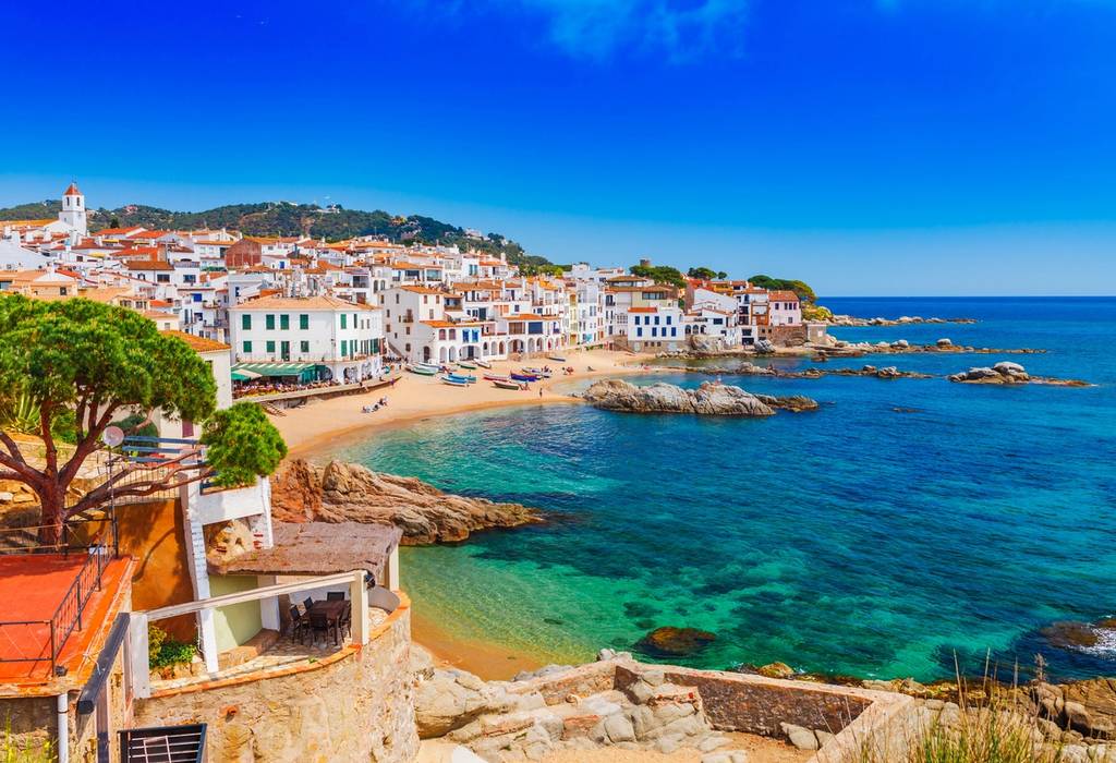 A view of the a scenic fisherman village with sand beach and clear blue water with a landscape of Calella de Palafrugell, Catalonia, Spain near of Barcelona