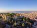 Aerial view of the turrets and walls of the São Jorge Castle atop a tree-covered hill in Lisbon