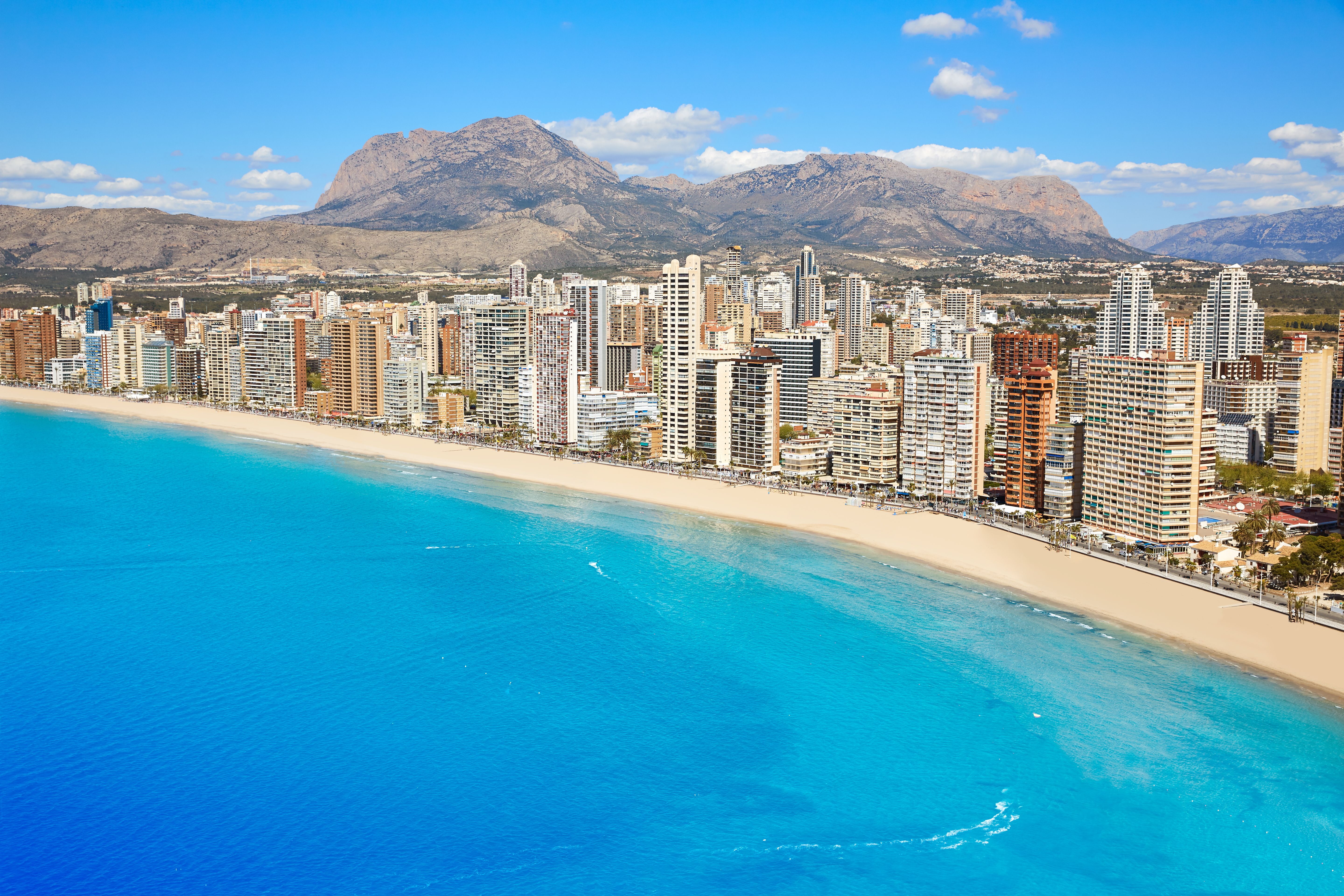An aerial view of Benidorm beach with high-rise buildings lining the beachfront