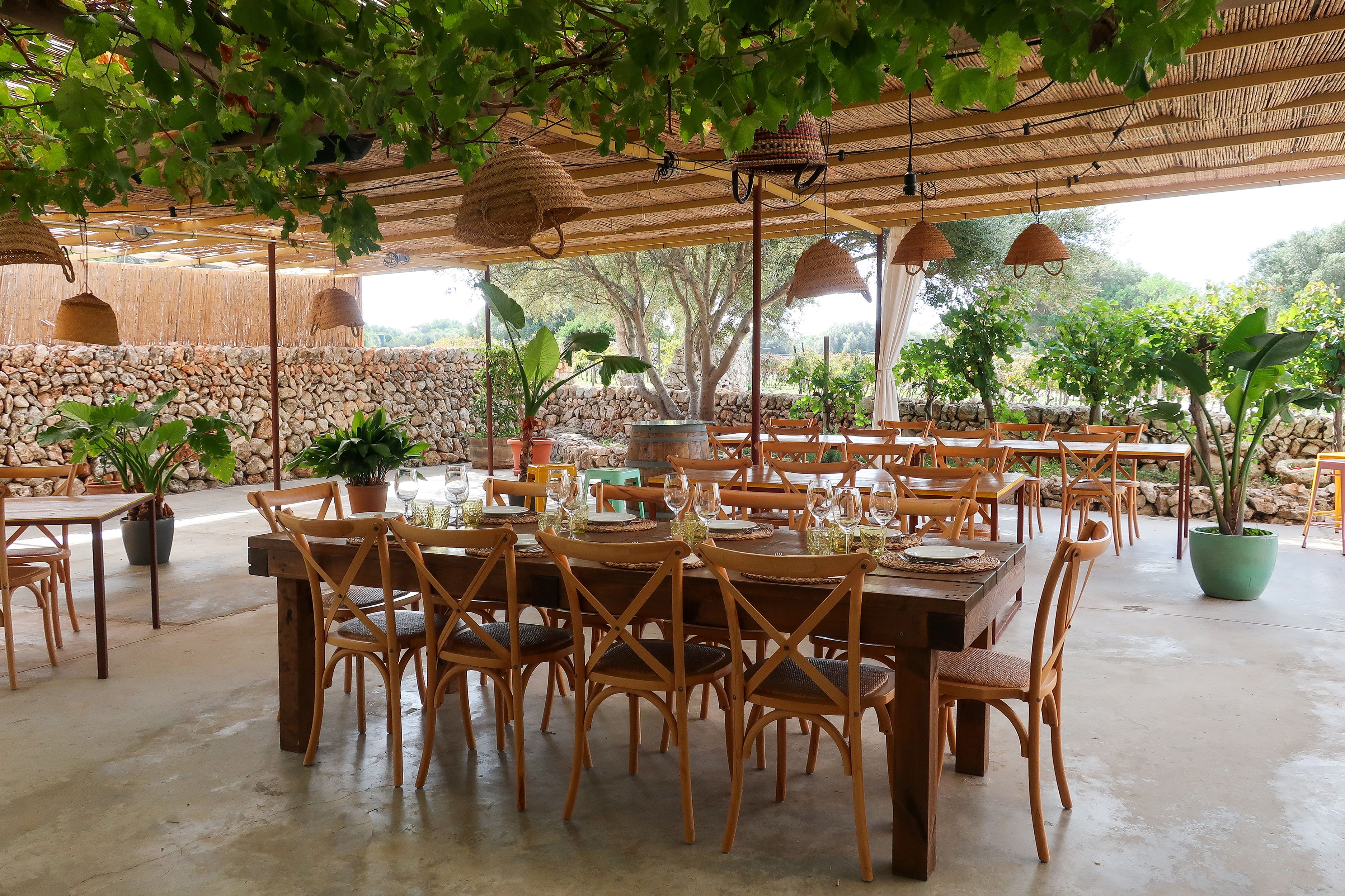 An outdoor dining table laid up for a meal on a terrace in Menorca