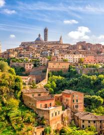 View of the terracotta-coloured buildings of the hilltop town of Siena in Tuscany