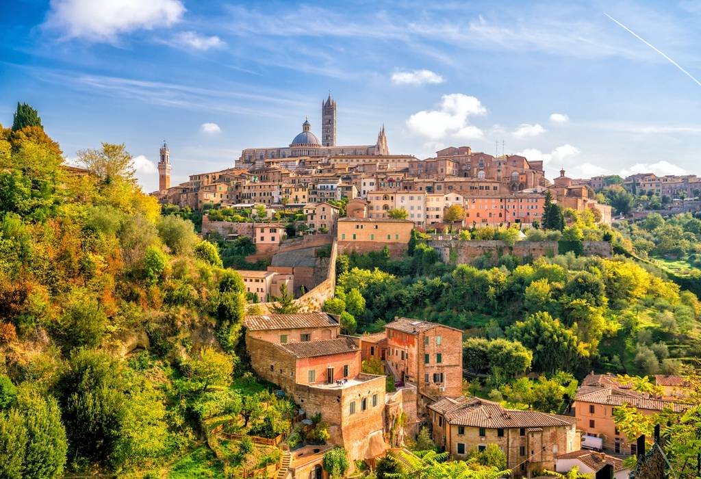 View of the terracotta-coloured buildings of the hilltop town of Siena in Tuscany