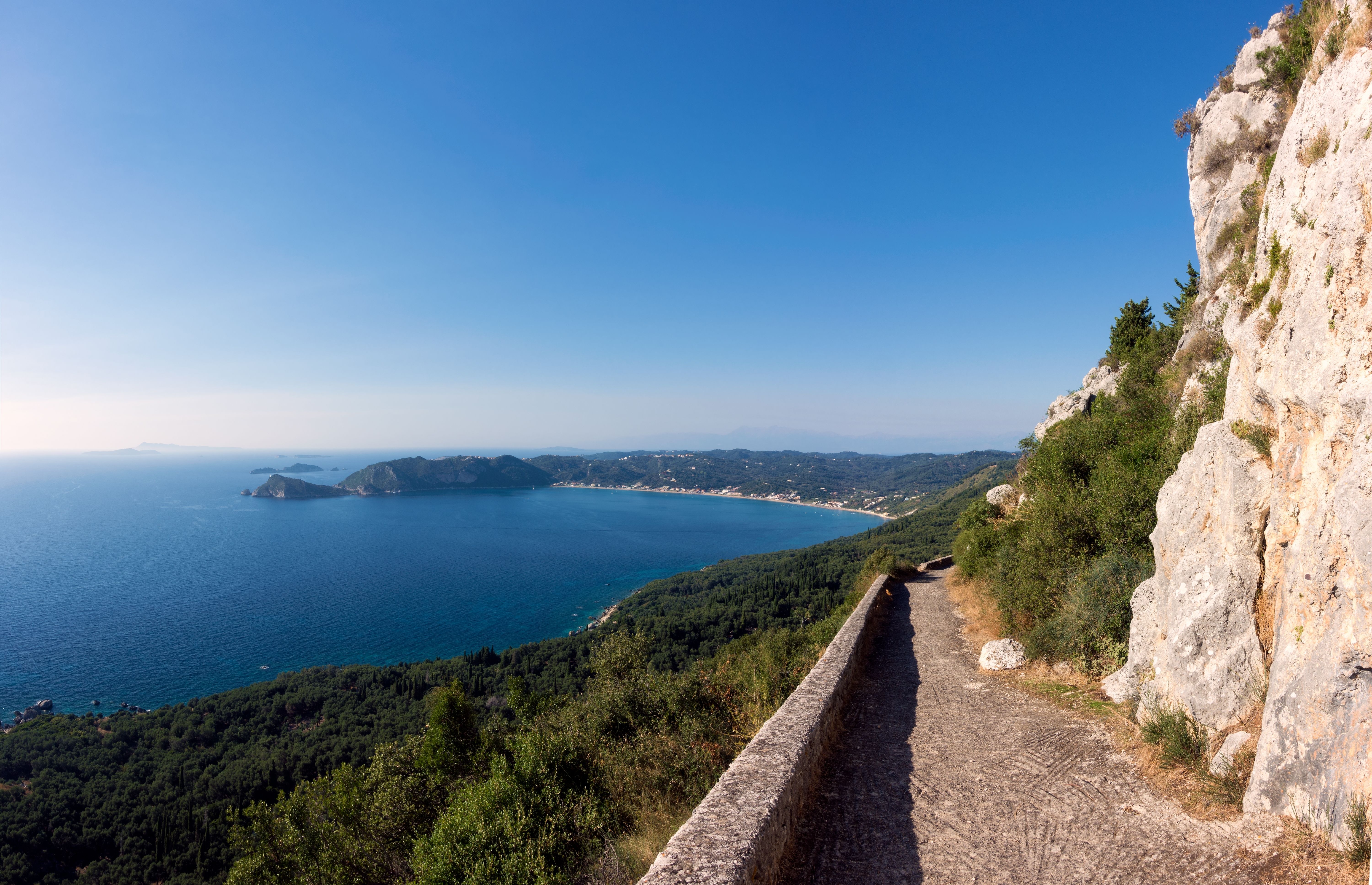 View of a narrow coastal path along a grassy cliffside.