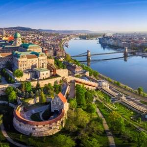 Aerial panoramic skyline view of Buda Castle Royal Palace with Szechenyi Chain Bridge and Hungarian Parliament at sunrise