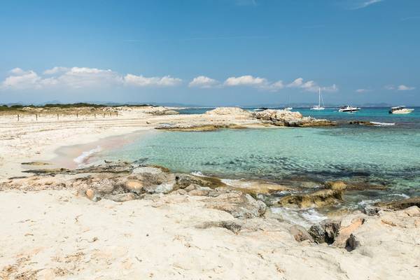 Picture of the tiny Balearic island of Espalmador that lies between Ibiza and Formentera with beautiful natural sandy beach and yachts anchored near the shore