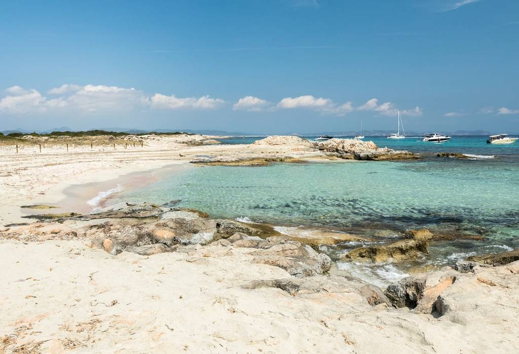 Picture of the tiny Balearic island of Espalmador that lies between Ibiza and Formentera with beautiful natural sandy beach and yachts anchored near the shore