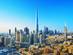 View of the Burj Khalifa in Dubai surrounded by city skyscrapers on a bright blue day