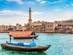 View of a ferry boat in Dubai Creek with ancient buildings in the background on a clear day