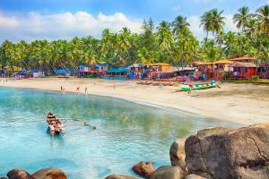 A picture of a beautiful Goa province beach in India with fishing boats and stones in the sea