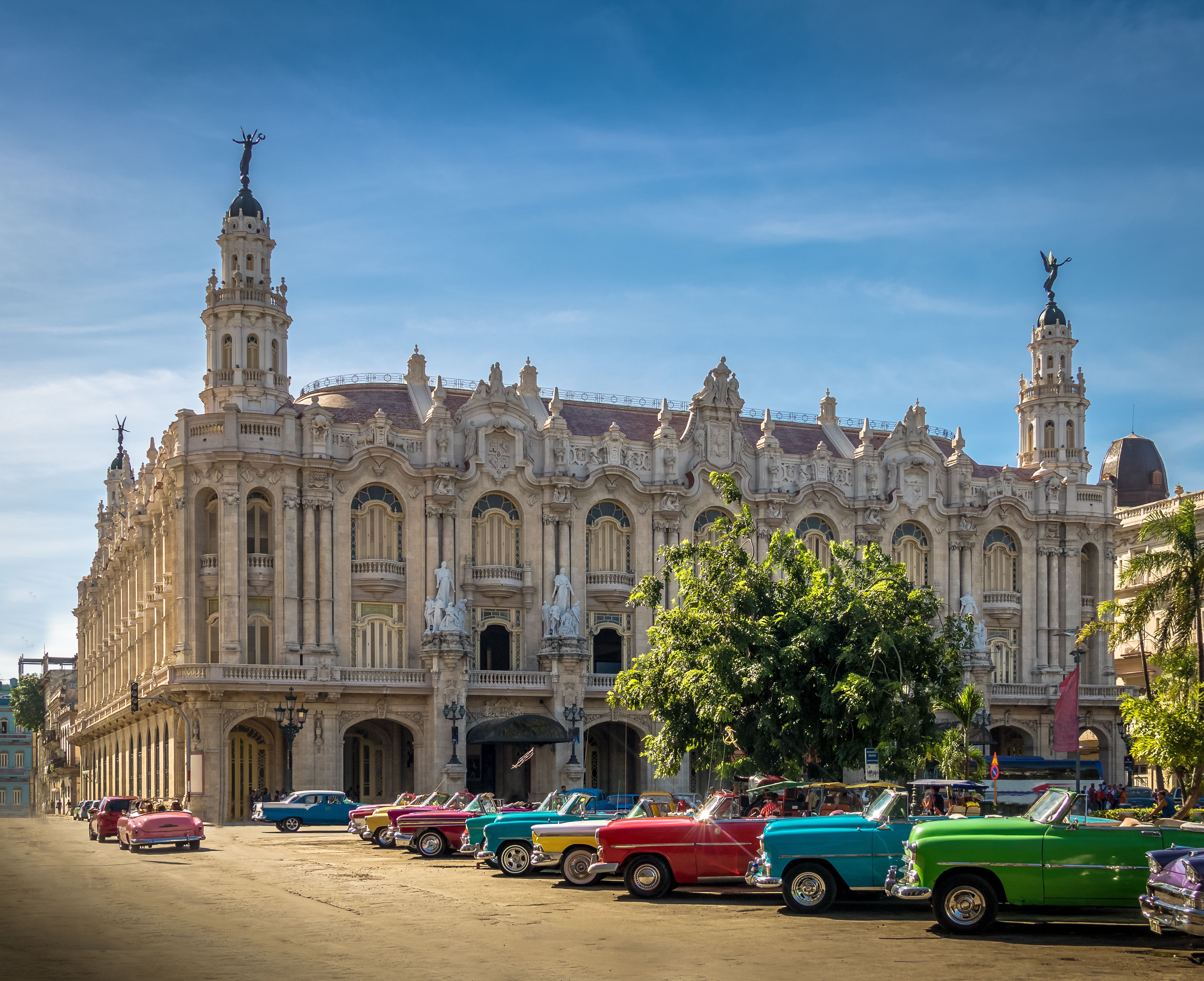 View of colourful vintage cars in front of a grand building in Havana, Cuba