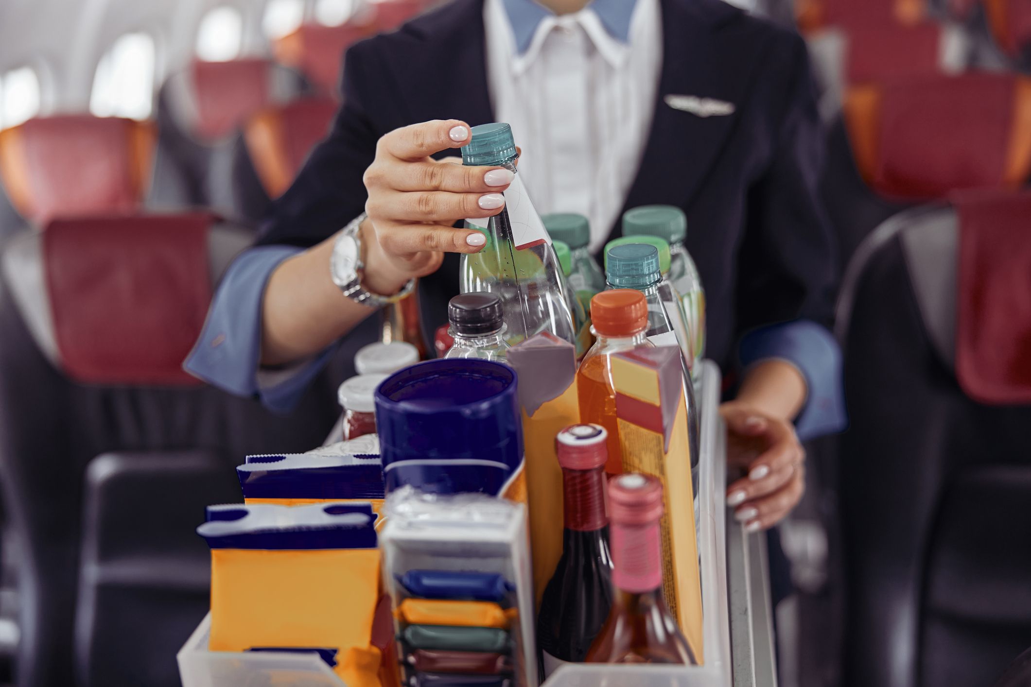 A close up shot of a drinks trolley in the aisle of a plane