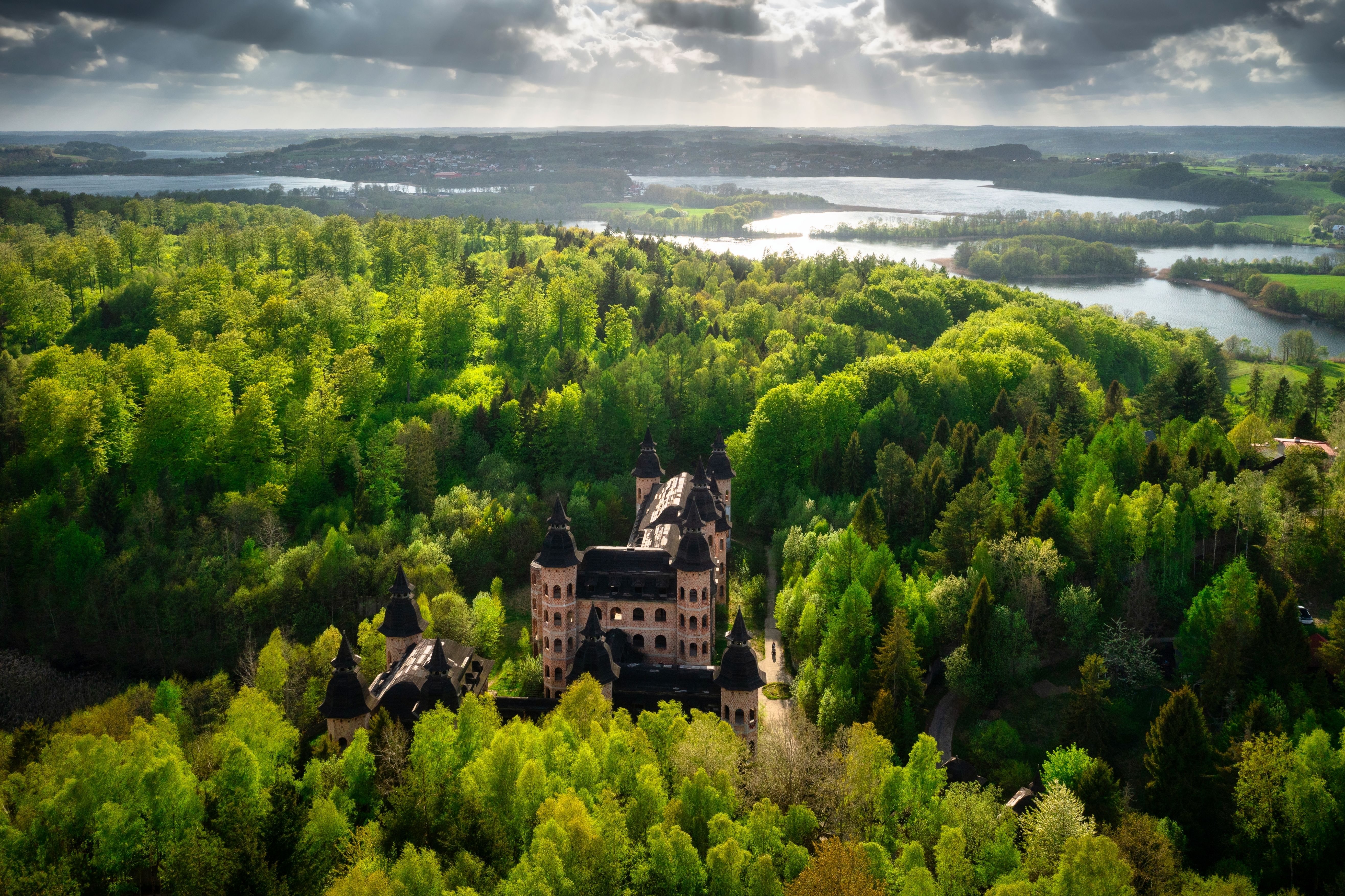 An aerial view of Lapalice Castle in the Pomorskie Province of Poland, surrounded by forest and lakes