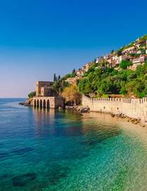 The medieval castle known as the Red Tower right on the clear, aqua waters of the Mediterranean in Alanya