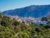 View of a whitewashed town nestled in a lush green valley in Spain.