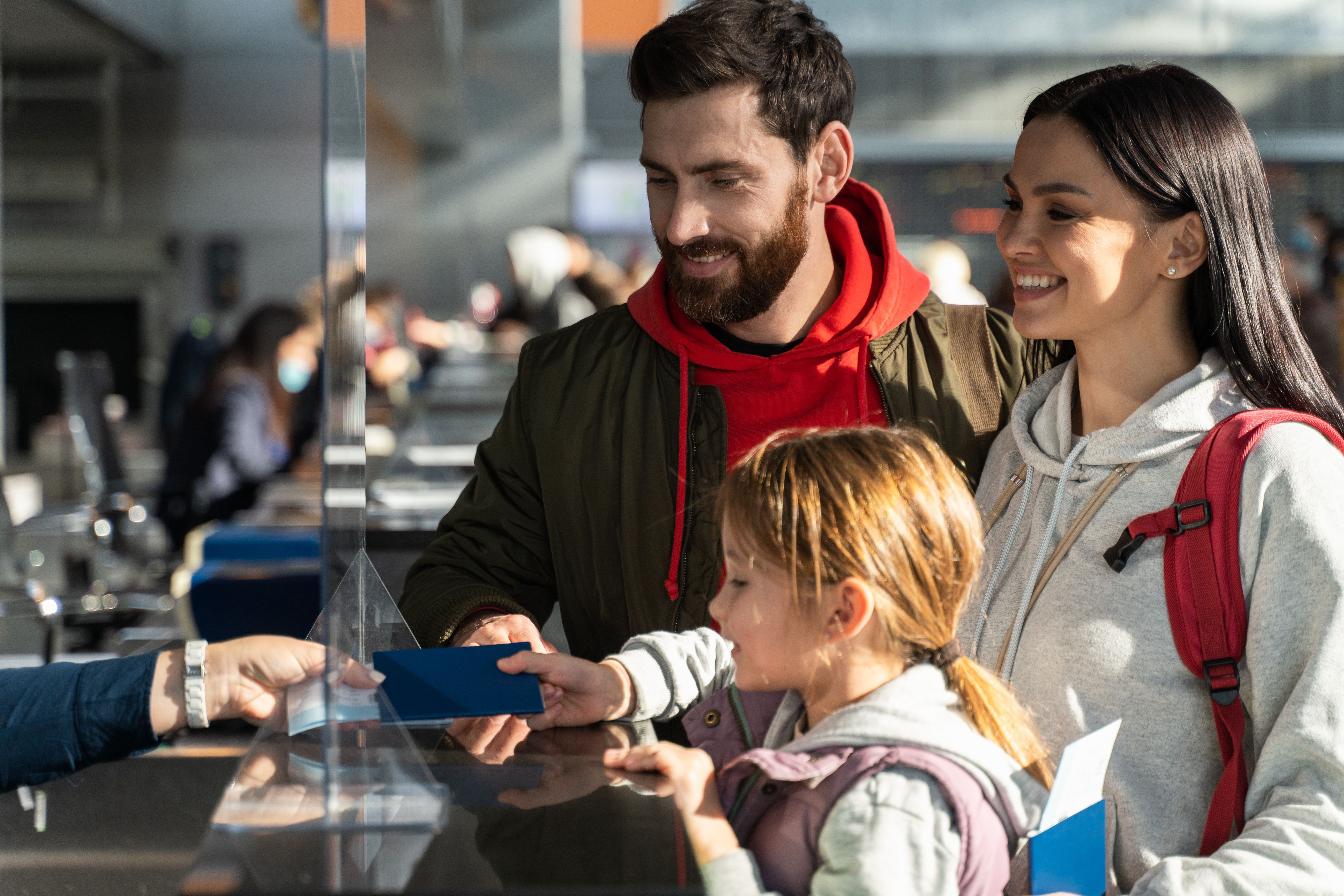 A family handing over their passports at an airport desk