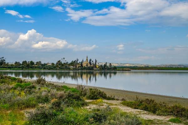 A view of an ancient mosque on the Aliki salt lake in Larnaca with reflection in the water on a spring day