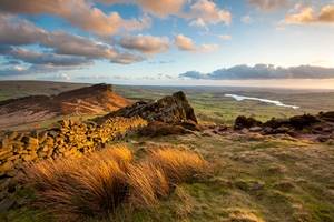 Wide angle view of warm sunset light on the hills and valleys near the Roaches in the Peak District