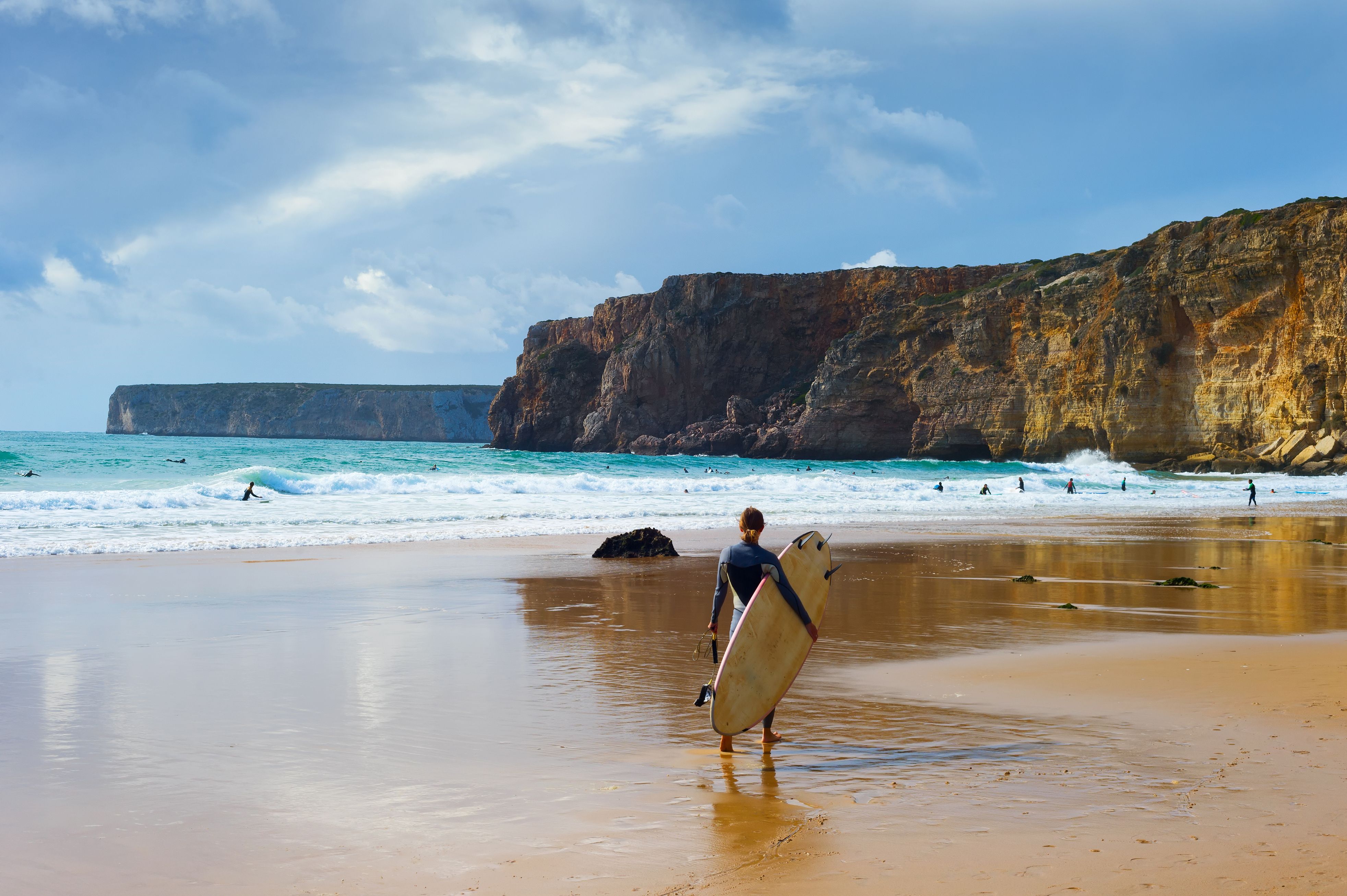 Surfers with surfboards on a beach in the Algarve, Portugal