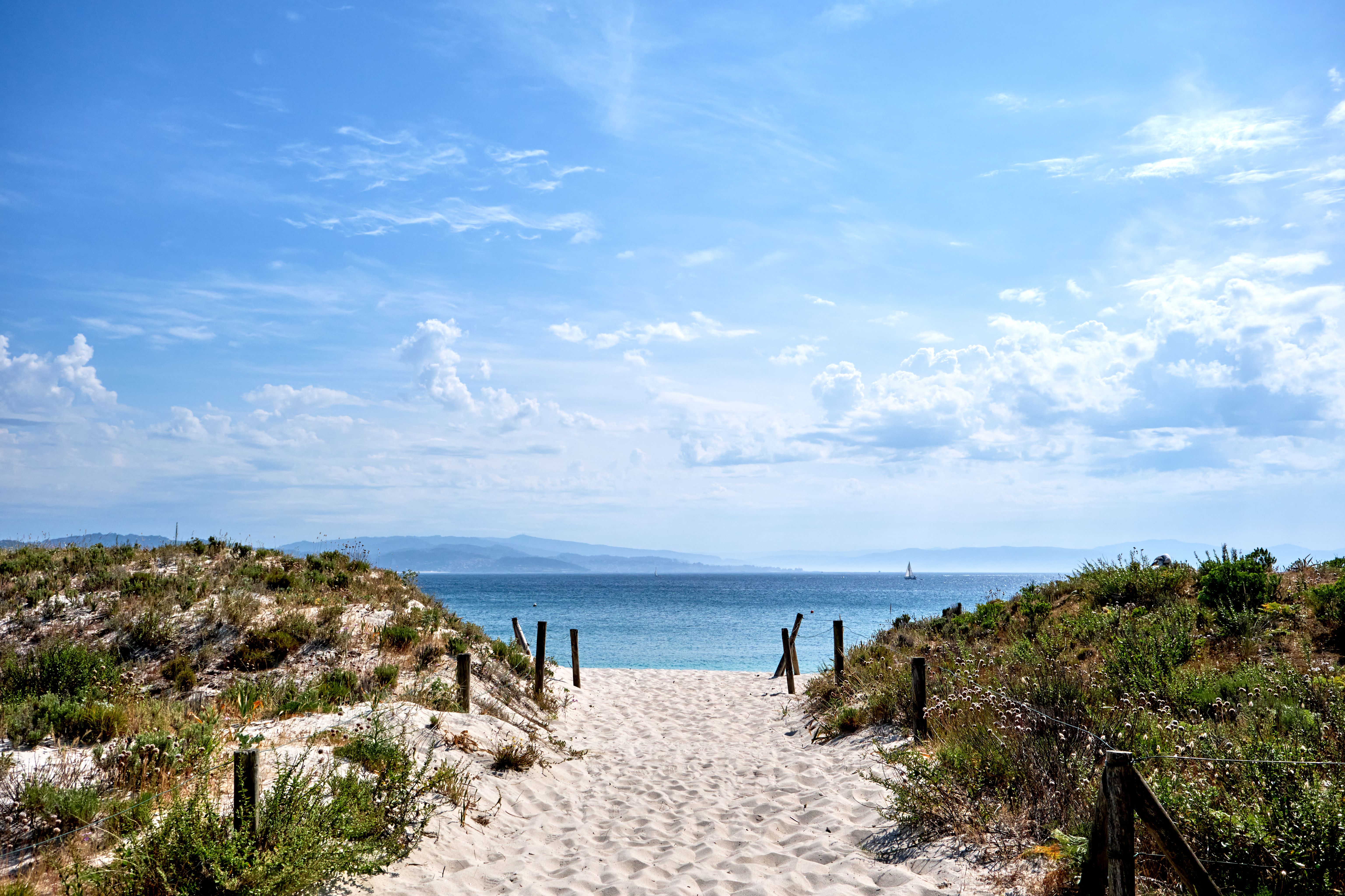 View along pristine white sand towards the ocean on a sunny day