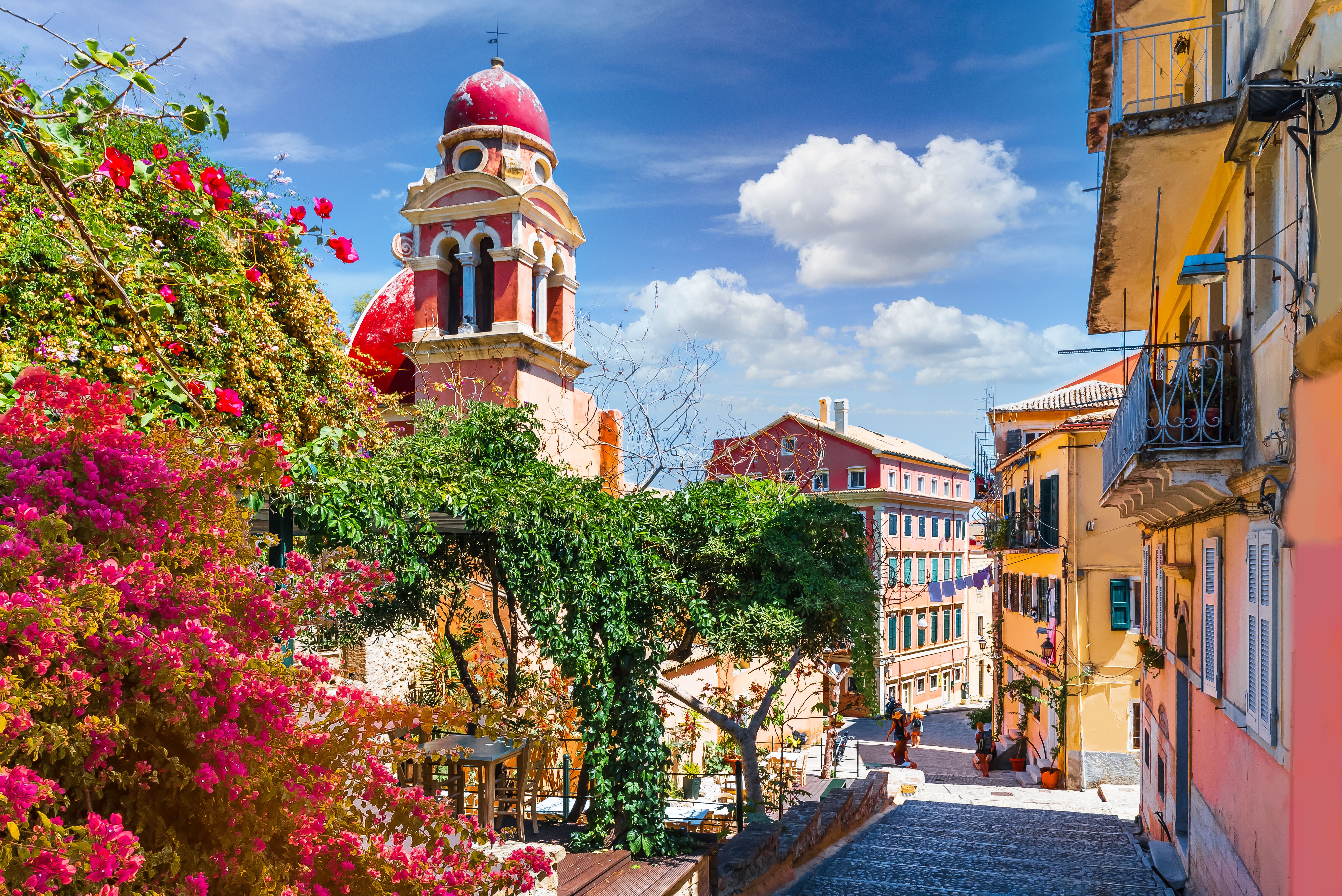Colourful buildings and a red-domed bell tower on a sunny day in Kerkyra, Corfu