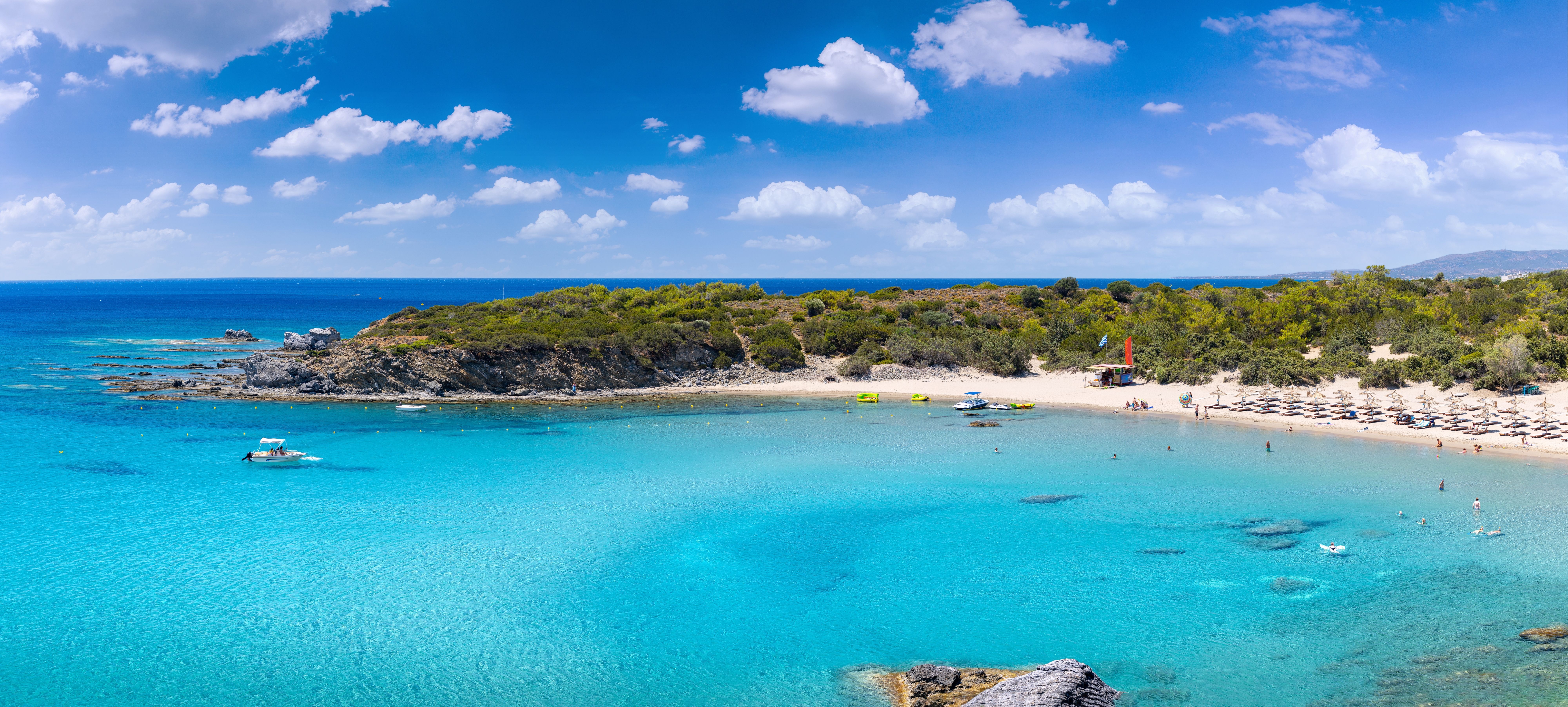 A view over Glystra beach in Rhodes with turquoise water and a white sandy bay