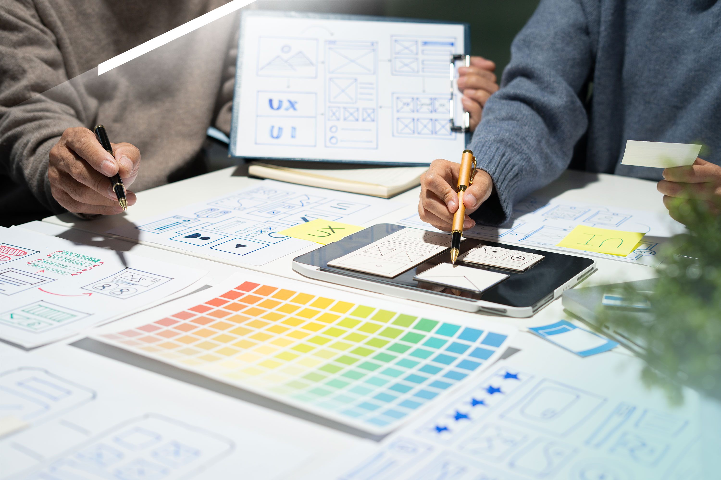 Team arbeitet an UX- und Content-Layouts mit Skizzen, Wireframes, Farbpaletten und digitalen Tools – Prozess der professionellen Content-Erstellung im Content-Marketing