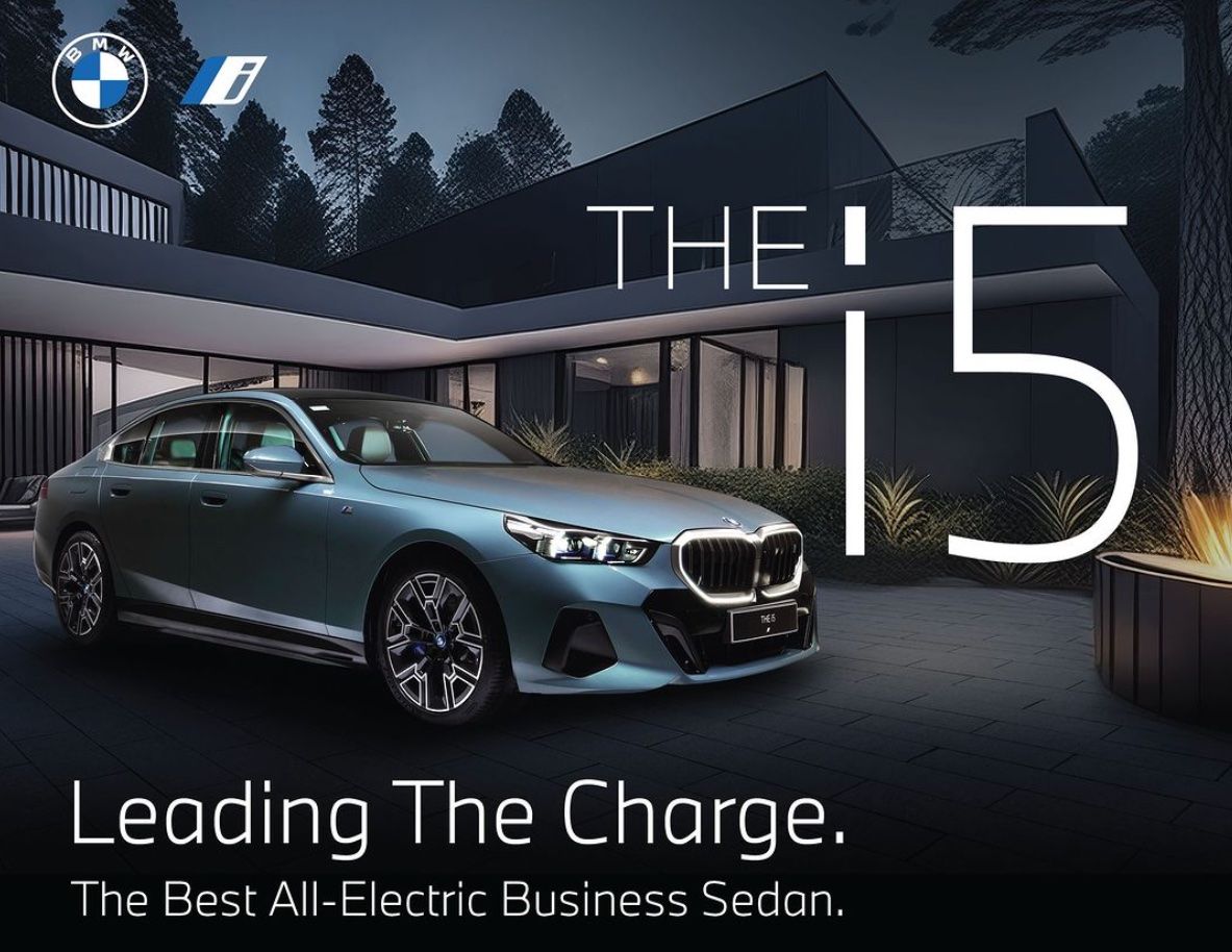 BMW i5 foran et flott hus