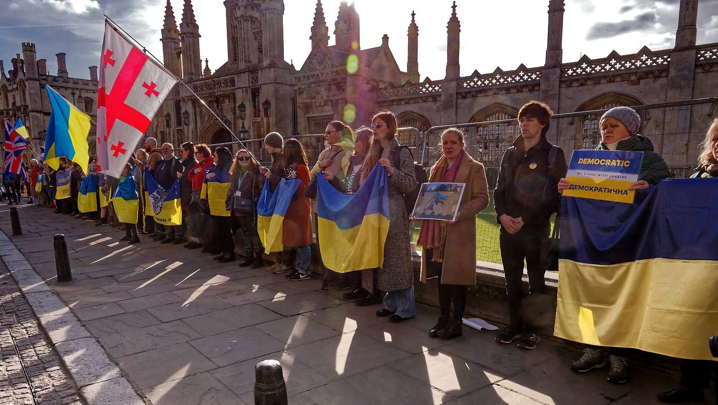 Supporters holding Ukrainian flags outside King’s College, Cambridge